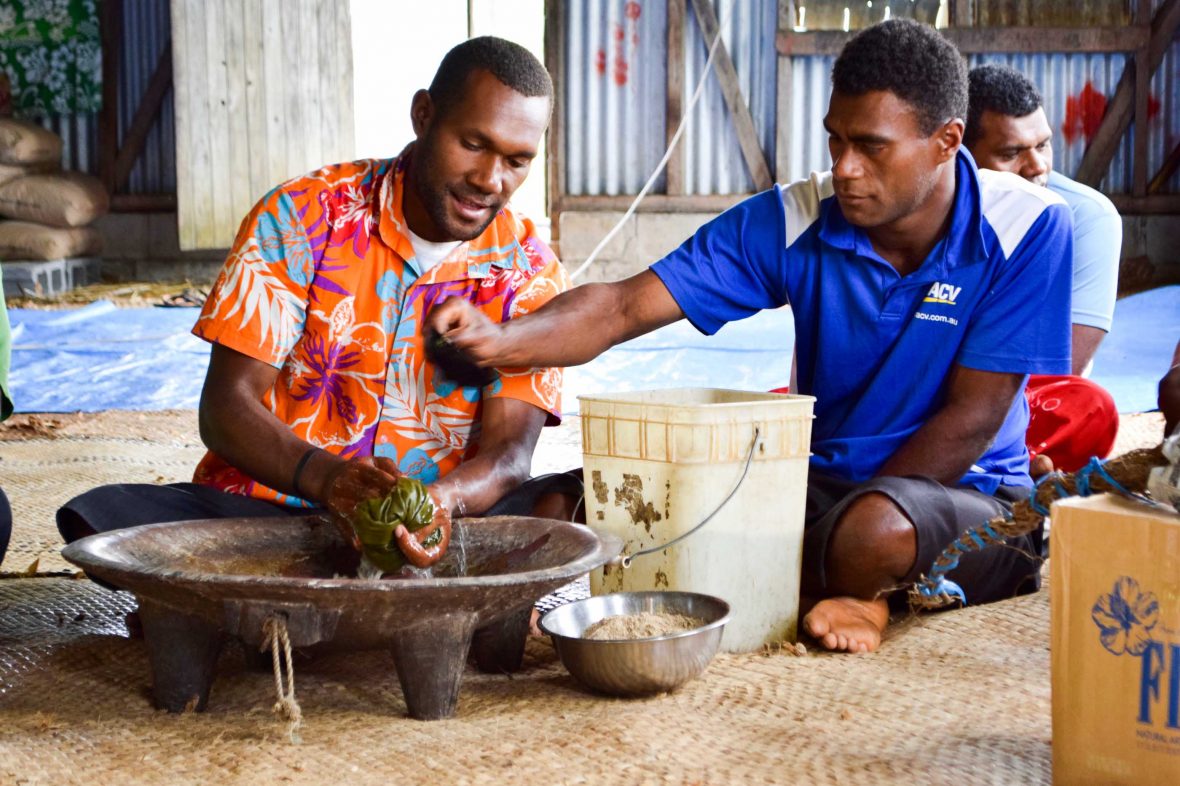 Two men prepare kava in Naga village.