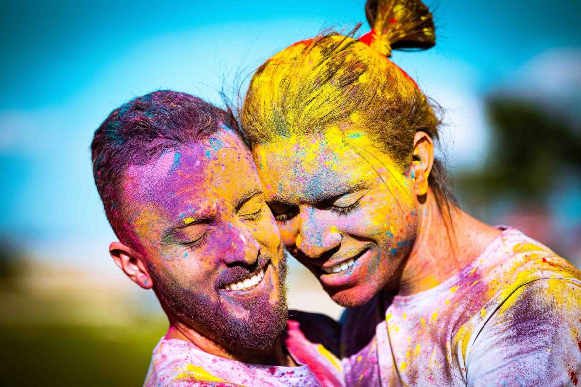 Two men covered in colored paints embrace in Brasilia, Brazil.