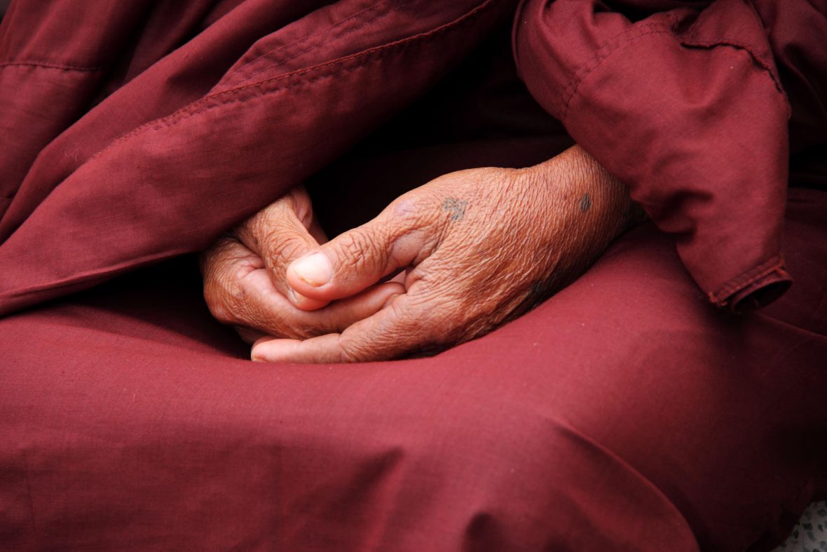 A monk crosses his hands in meditation.